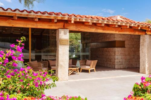 un patio con pérgola de madera y flores en AMASEA Resort, en San Teodoro