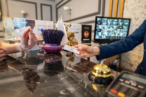 una persona che consegna una carta di credito a un cliente presso un banco di Hamit Hotel Kizilay a Ankara