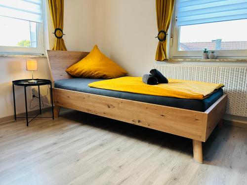 a wooden bed in a room with a window at Gästehaus Trockau in Pegnitz