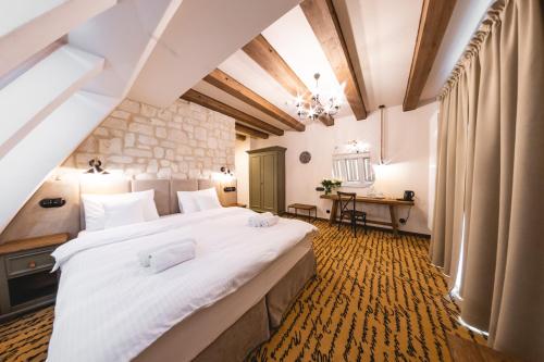 um quarto com uma grande cama branca num quarto em Dwór Bogucin Hotel&Restauracja em Bogucin