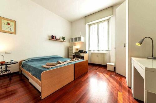 a bedroom with a bed and a desk and a window at SAN SIRO a 7 minuti Stanza Top con zone Comuni in Milan