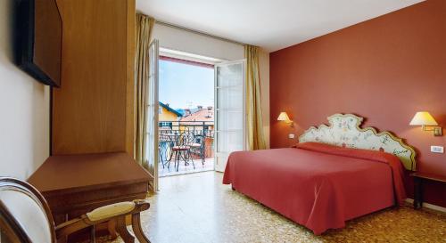 a bedroom with a red bed and a balcony at Residenza dei Fiori in Cannero Riviera