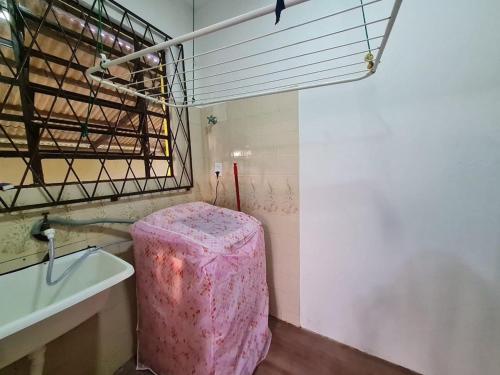 - une salle de bains avec un tabouret rose à côté d'un lavabo dans l'établissement RCM Vilas - YELLOW HOUSE, à Joinville