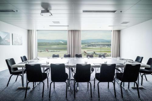 een grote vergaderzaal met een grote tafel en stoelen bij Radisson Blu Hotel Zurich Airport in Kloten