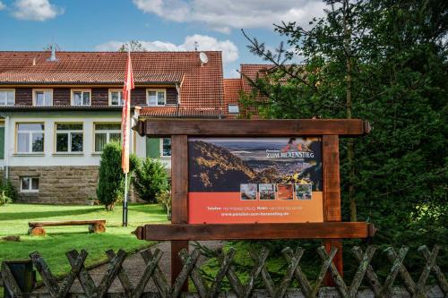 um sinal num quintal com uma casa ao fundo em Pension zum Hexenstieg em Schierke