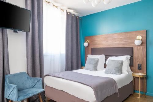 een slaapkamer met een bed en een blauwe muur bij The Originals Boutique, Hôtel Le Marignan,Le Havre Centre Gare in Le Havre