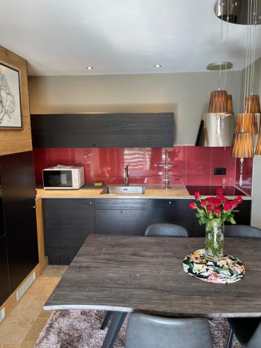 una cocina con una mesa de madera y un jarrón de flores en Luxury apartment, en Crans-Montana