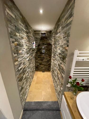 baño con pared de piedra en Luxury apartment, en Crans-Montana