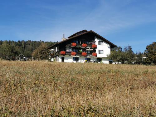 a house with flowers on the side of a field at Erlebnishaus Spiess in Feldkirchen in Kärnten