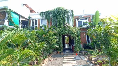 una casa con un camino que conduce a la puerta principal en Wow Farm House, en Auroville