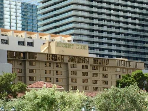 un bâtiment d'hôtel avec un panneau en haut dans l'établissement Jockey Resort Suites Center Strip, à Las Vegas