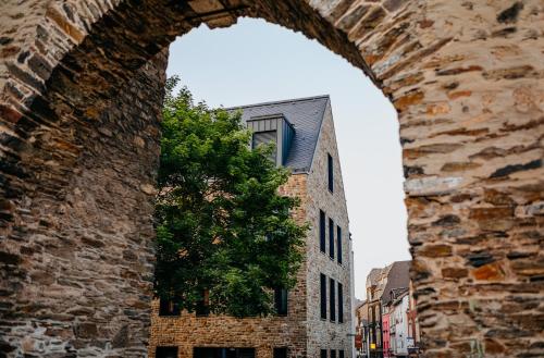 a brick building with a tree in front of it at Hotel am Ochsentor in Andernach