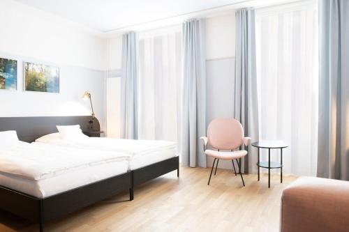 a bedroom with a bed and a chair and a table at Hotel Schützen Rheinfelden in Rheinfelden