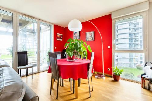 ein rotes Esszimmer mit einem roten Tisch und Stühlen in der Unterkunft Location chambre privée avec salle de bain et WC privatifs dans appartement moderne in Nantes