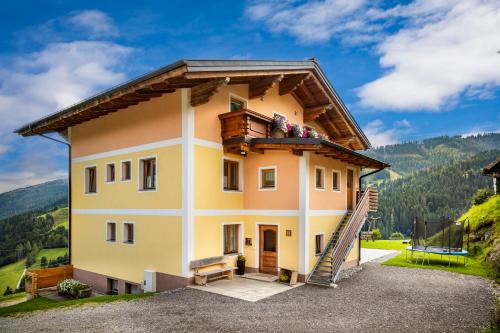 uma casa com varanda nas montanhas em Brennergut Ferienwohnung am Bauernhof em Mühlbach am Hochkönig