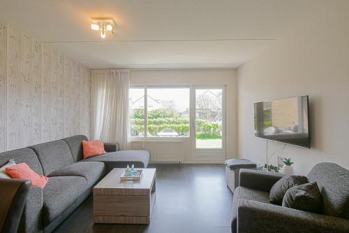 - un salon avec deux canapés et une télévision dans l'établissement Beach Appartement 14 - Callantsoog, à Callantsoog