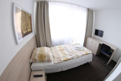 - une chambre avec un lit et une grande fenêtre dans l'établissement Hotel SPECTRUM, à Trnava