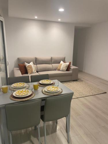 ein Wohnzimmer mit einem Tisch und Teller mit Lebensmitteln darauf in der Unterkunft Modern Spacious Apartment in Entroncamento