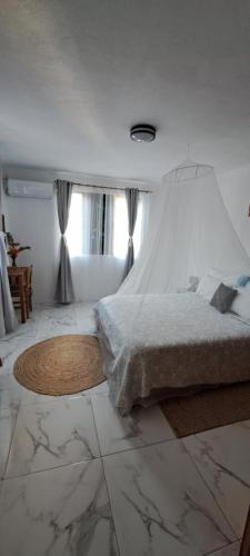 a bedroom with a bed with a white comforter at Résidence au bout du Morne in Le Morne