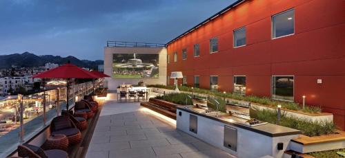 a balcony of a red building with tables and chairs at Luxury Apartment West Hollywood in Los Angeles