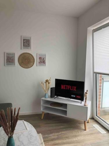 sala de estar con TV de pantalla plana sobre una mesa en Moderne Neue 2 Zimmer Wohnung, en Uetersen