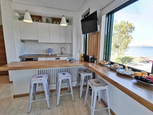 cocina con encimera con taburetes y ventana grande en apartamento Vigo Samil, en Vigo