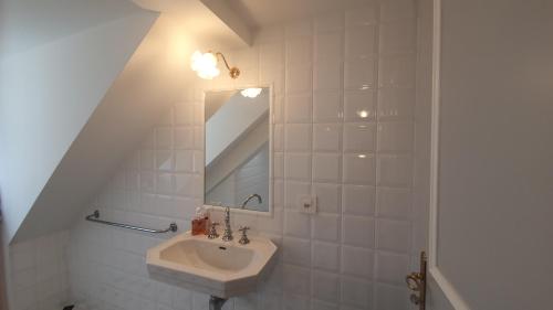 y baño con lavabo y espejo. en Le Faubourg 29, en Neuchâtel