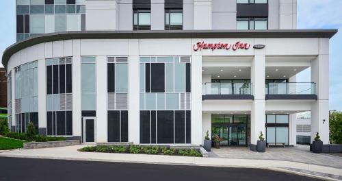 a white building with a red sign on it at Hampton Inn By Hilton Hamilton in Hamilton