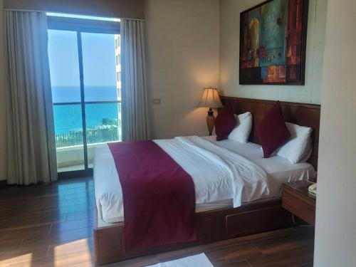 Schlafzimmer mit einem Bett und Meerblick in der Unterkunft King Suites Hotel in Beirut