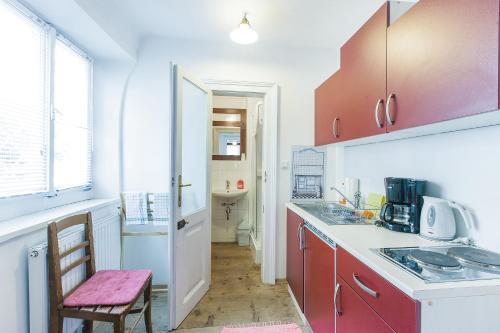 una cocina con armarios rojos y una silla rosa en Stadthaus Mariazell, en Mariazell