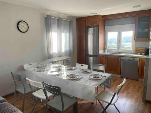 une cuisine avec une table et des chaises blanches ainsi qu'une cuisine avec une table et des chaises dans l'établissement Casa da Baltasara, à Trives