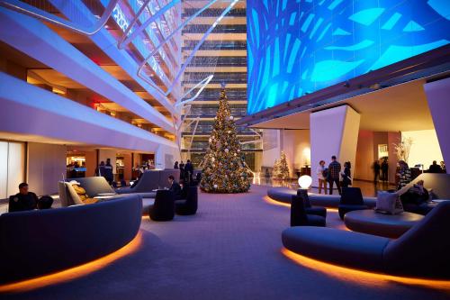 een kerstboom in het midden van een lobby met mensen bij Conrad New York Downtown in New York