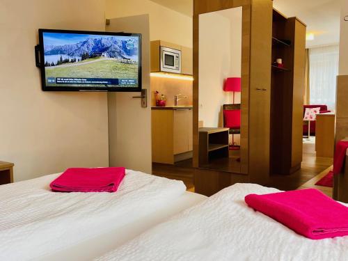 um quarto de hotel com duas camas e uma televisão de ecrã plano em Aparthotel Bergtraum em Mühlbach am Hochkönig