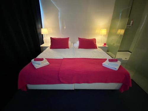 - une chambre avec un grand lit et une couverture rouge dans l'établissement Business Hotel Wiesbaden PRIME, à Wiesbaden