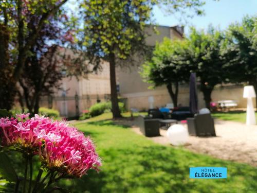 a pink flower in the grass in a yard at Logis Hôtel de l'Europe in Poitiers