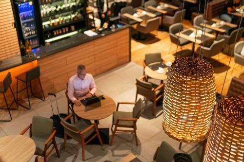 un homme assis à une table dans un restaurant dans l'établissement Novotel Curitiba Batel, à Curitiba