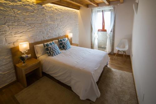 a bedroom with a bed and a stone wall at Casa Juancito in Santiago de Compostela