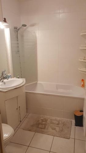 ein Badezimmer mit einem Waschbecken, einer Badewanne und einem WC in der Unterkunft Location chambre privée avec salle de bain et WC privatifs dans appartement moderne in Nantes