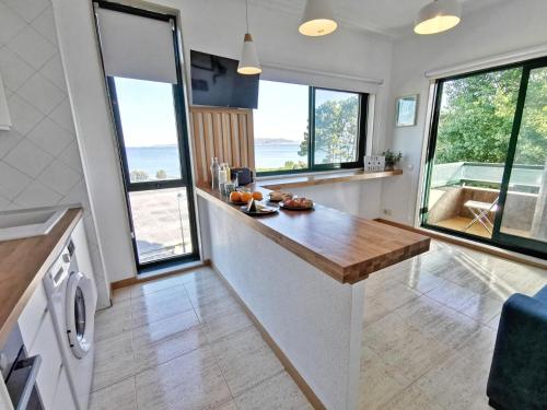 cocina con encimera y algunas ventanas en apartamento Vigo Samil, en Vigo