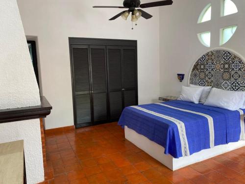 - une chambre avec un lit et un ventilateur de plafond dans l'établissement Casa Yollotzin, à Ajijic