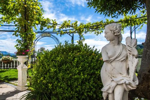 Una statua di una donna seduta in un giardino di Hotel Scapolatiello a Cava deʼ Tirreni