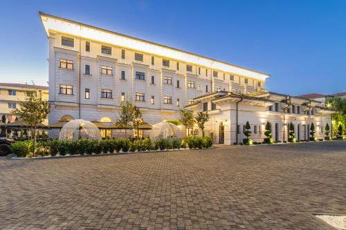 un grande edificio bianco con cupole in un cortile di ZET Hotel a Timişoara