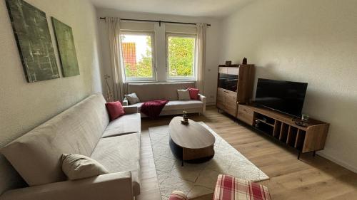 uma sala de estar com um sofá e uma televisão em Bitterfelder Cityapartment im Dichterviertel em Bitterfeld