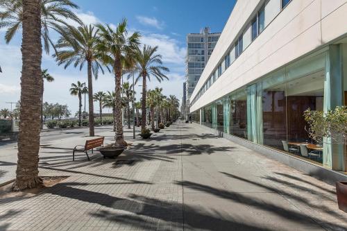 un marciapiede con palme accanto a un edificio di Hotel Best Front Maritim a Barcellona