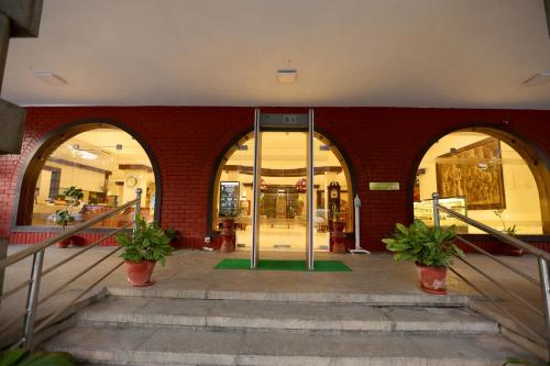 una entrada a un edificio con dos puertas y escaleras en Breeze Residency, en Tiruchchirāppalli