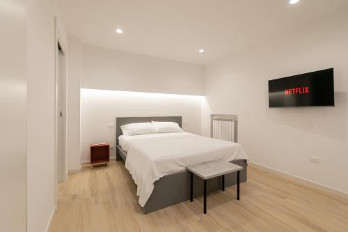 a bedroom with a bed and a tv on a wall at Maison Nona in Torre del Greco