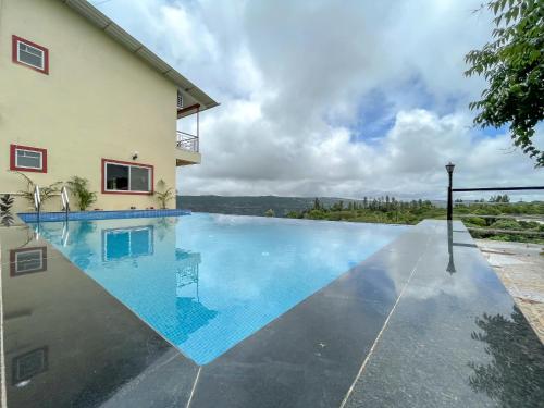 una piscina di fronte a una casa di Elsewhere Villa by Hill Staytion a Mahabaleshwar