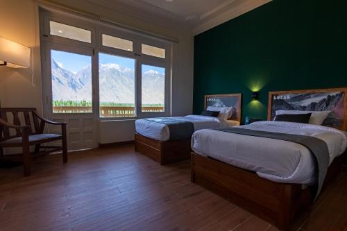 a bedroom with two beds and a large window at LOKAL x Skardu (City Center) in Skardu