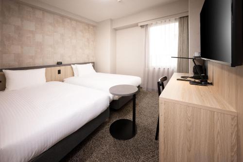 Кровать или кровати в номере Shizutetsu Hotel Prezio Osaka Shinsaibashi