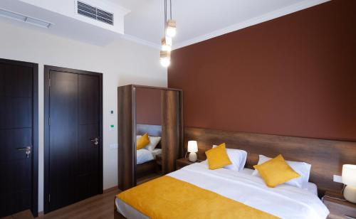 um quarto com uma cama grande e almofadas amarelas em Hotel Avenue 106 em Tbilisi